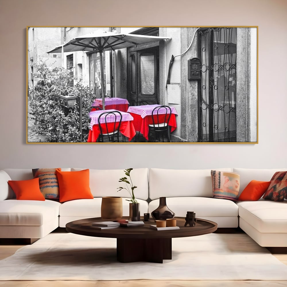 Tablou canvas cu cafenea stradala vintage alb negru cu pete de rosu, in rama de aluminiu auriu, pe perete intr-un living